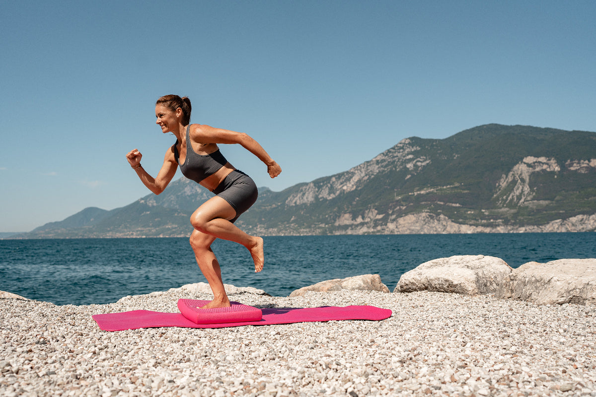 Airex Balance-pad Elite pink, Anwendung am See beim einbeinigen Lauftraining auf Steinen, für Gleichgewichtstraining