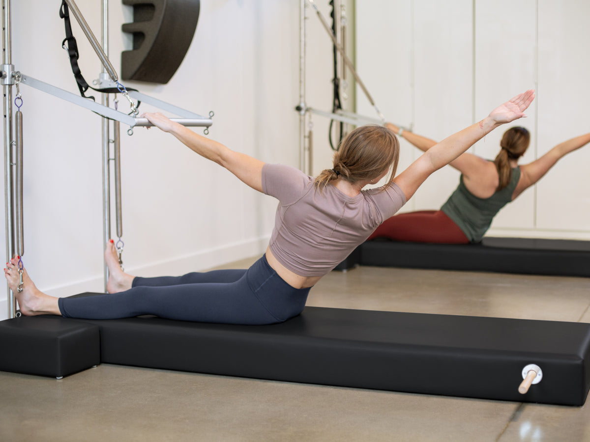 Balanced Body Black Raised Mat with Moon Boxes, used on the Wall Tower during Pilates training